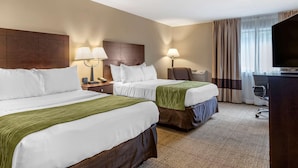 A hotel room with two beds, a desk, a chair, a TV, and a window with curtains. - Comfort Inn Lansing West (Lansing)