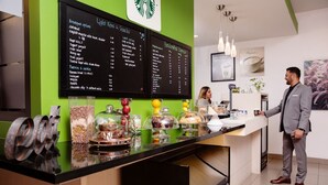 Een Starbucks toonbank met een menubord waarop ontbijt- en lunchgerechten staan aangeboden.