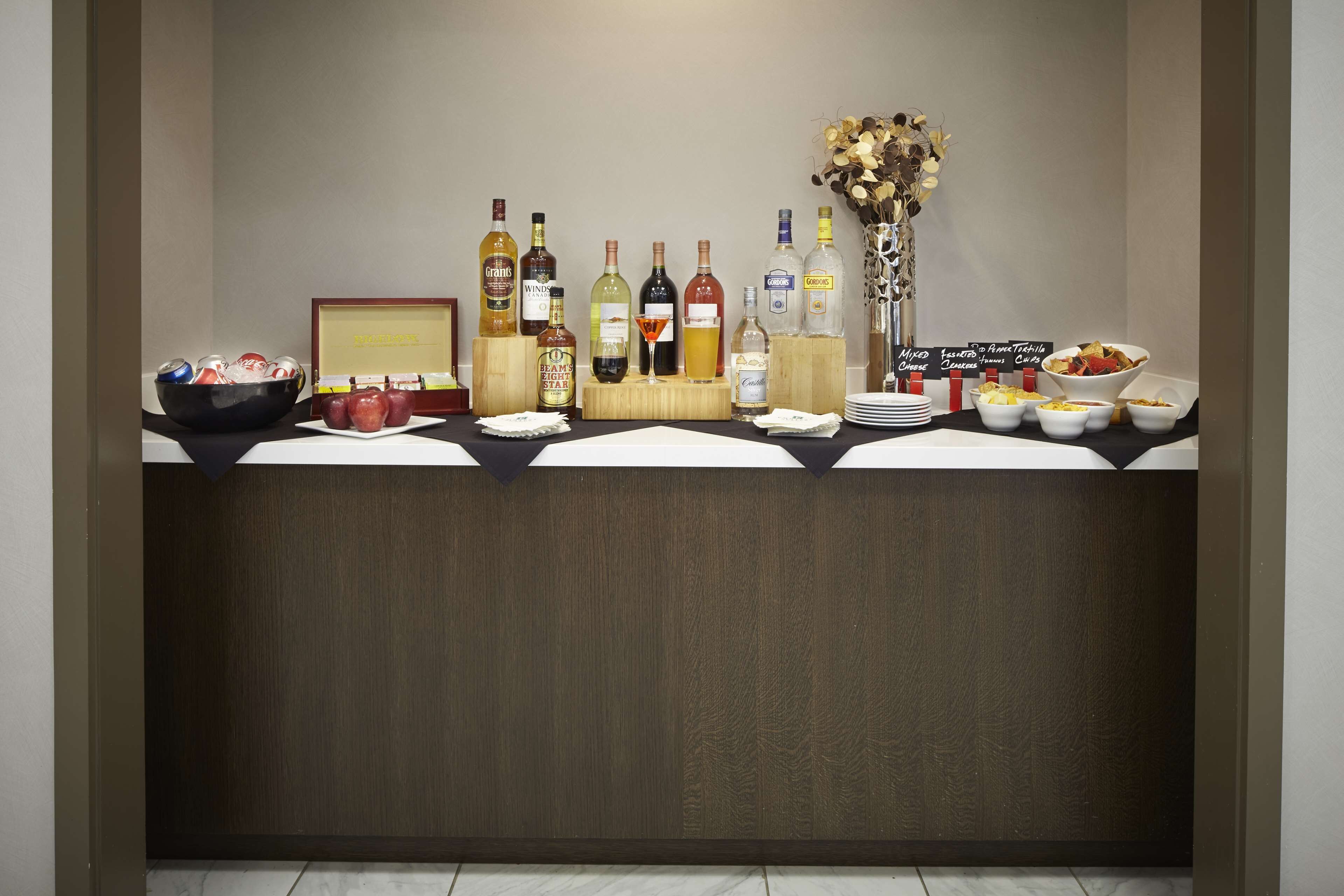 A buffet setup with various food items and a selection of beverages.