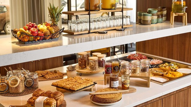 Un bufé de desayuno con diversas opciones de comida y bebidas.