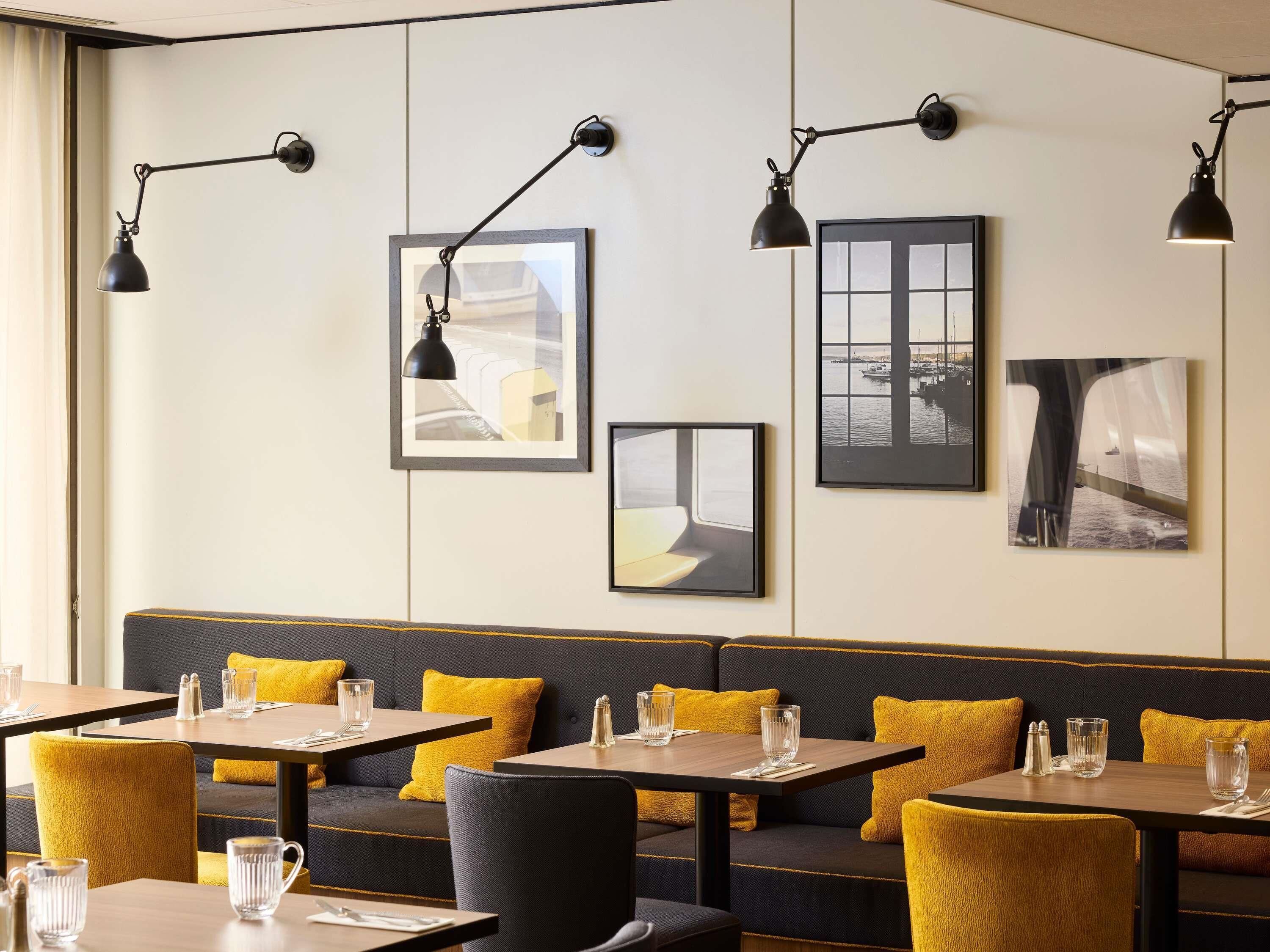 A restaurant interior with tables, chairs, and a bench area.
