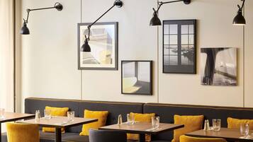 A restaurant interior with tables, chairs, and a bench area.