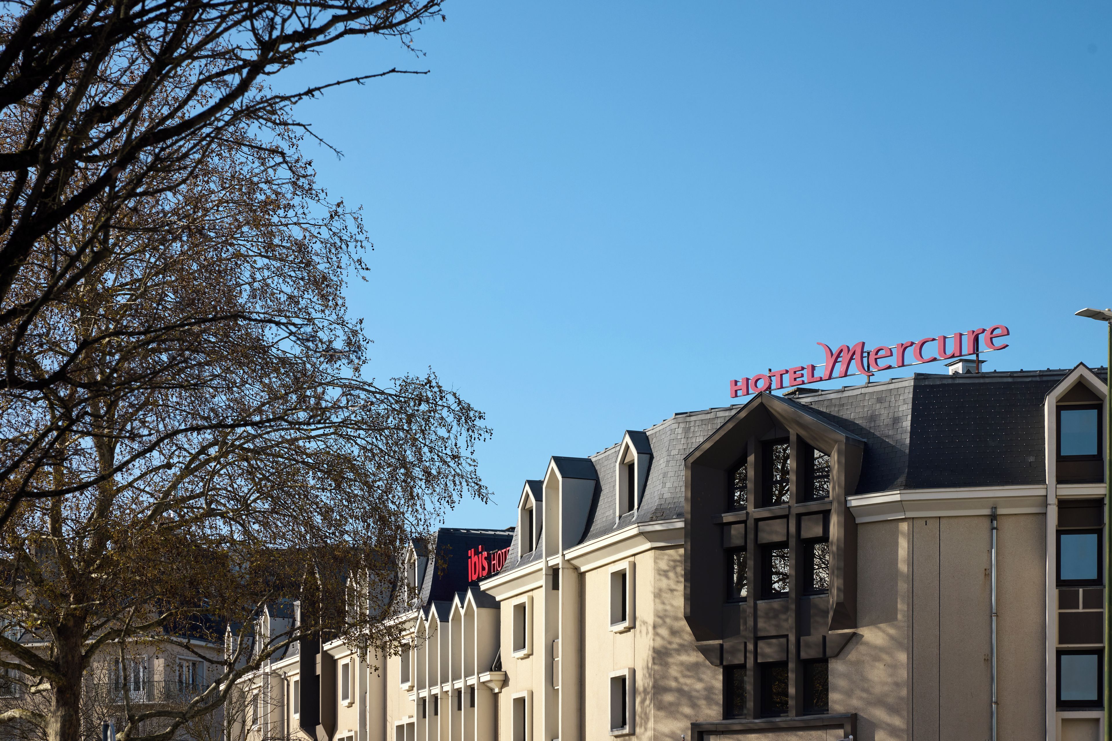 A row of buildings with a prominent red sign reading 'Mercure Hotel'.