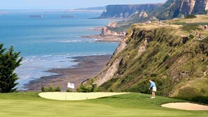 Un campo de golf con vistas al océano y a los acantilados.