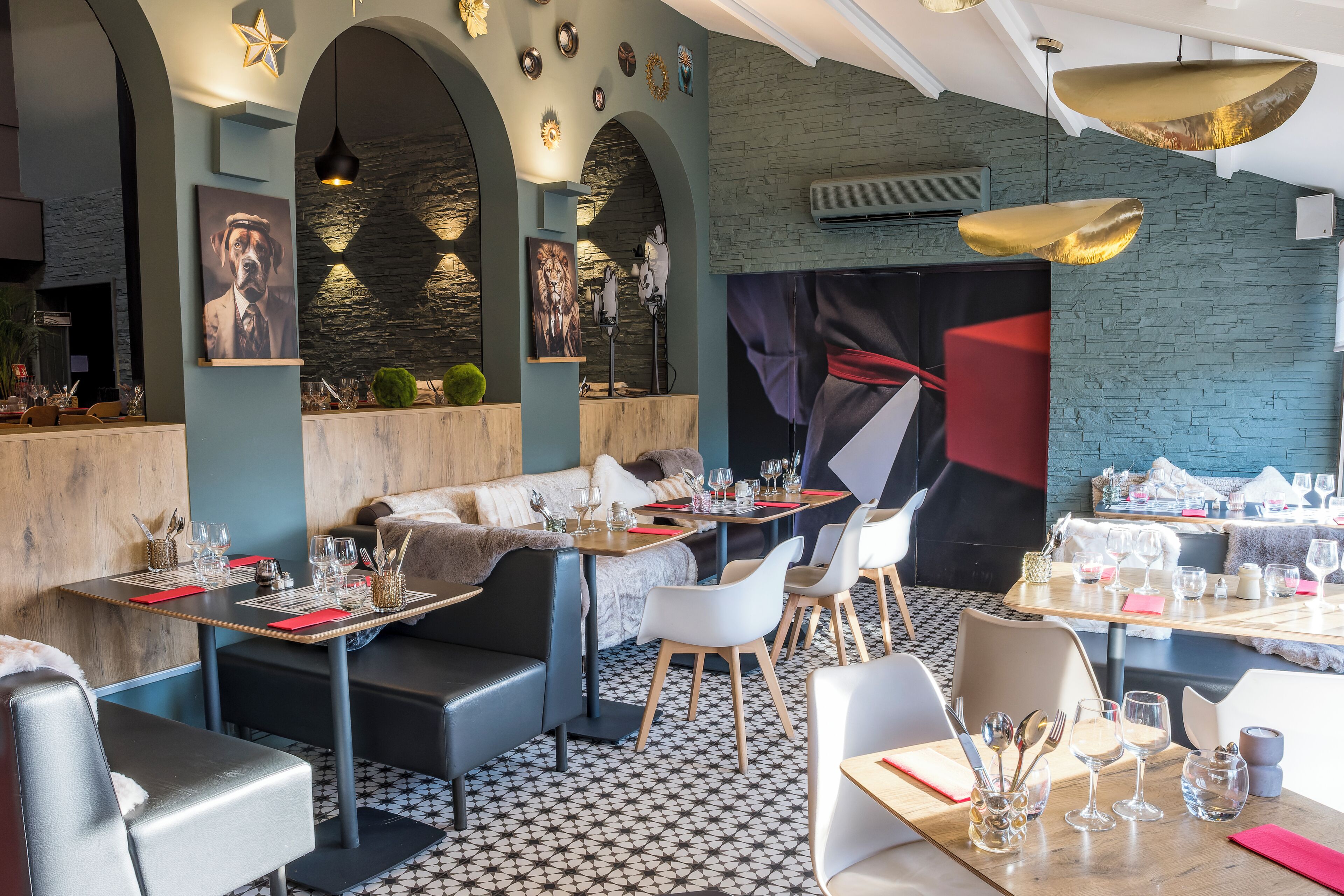 A modern restaurant interior with high tables, comfortable seating, and decorative wall art.