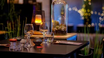 Una mesa dispuesta con vasos, una botella y una carta.
