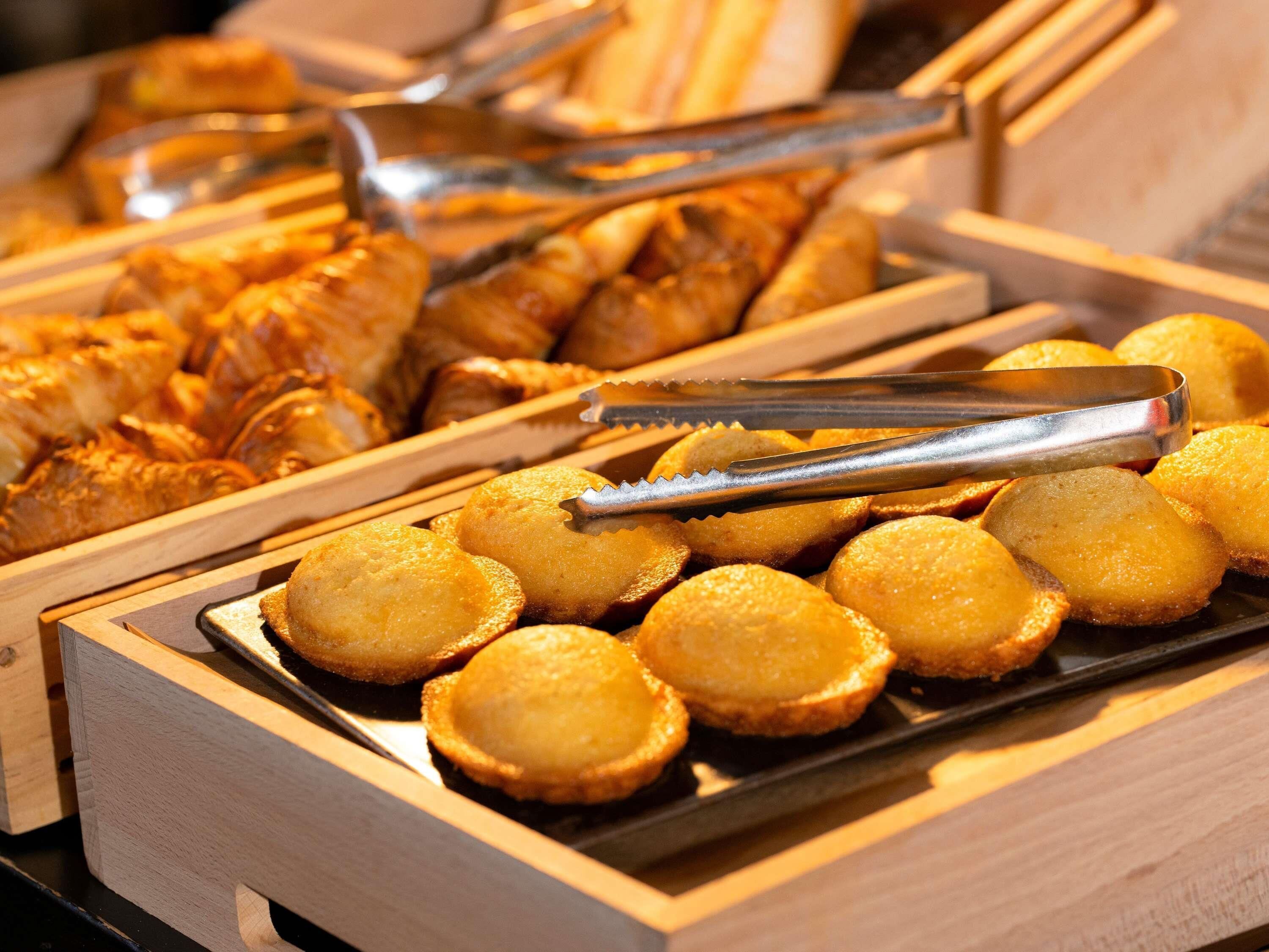A buffet with various baked goods, including pastries and bread.