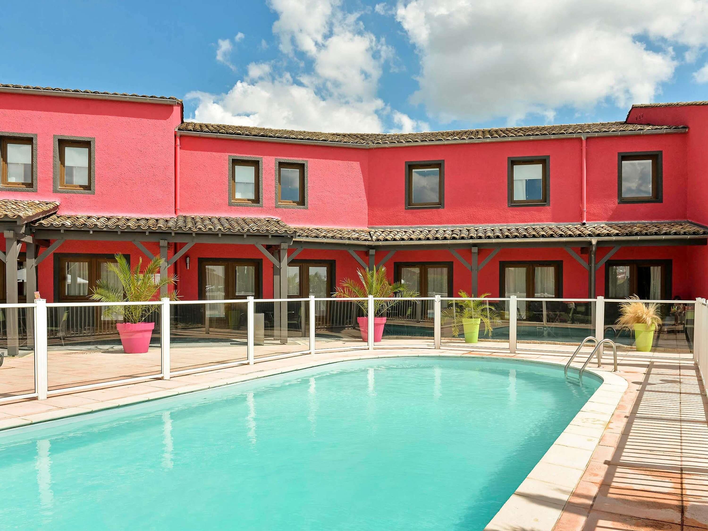 A pool area with a red building in the background.