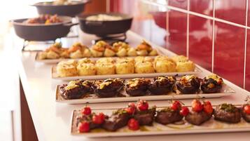 Een buffet met diverse gerechten, waaronder gevulde groenten en vlees.