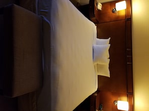 A hotel room with a bed, a nightstand, and two bedside lamps. - The Hotel Fresno (Fresno)