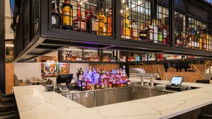 A bar area with a marble countertop, shelves of liquor bottles, and a computer monitor. - Hyatt Regency Princeton (Princeton)
