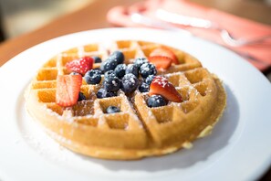 A close-up of a waffle with strawberries and blueberries on a white plate. - Hyatt Regency Princeton (Princeton)