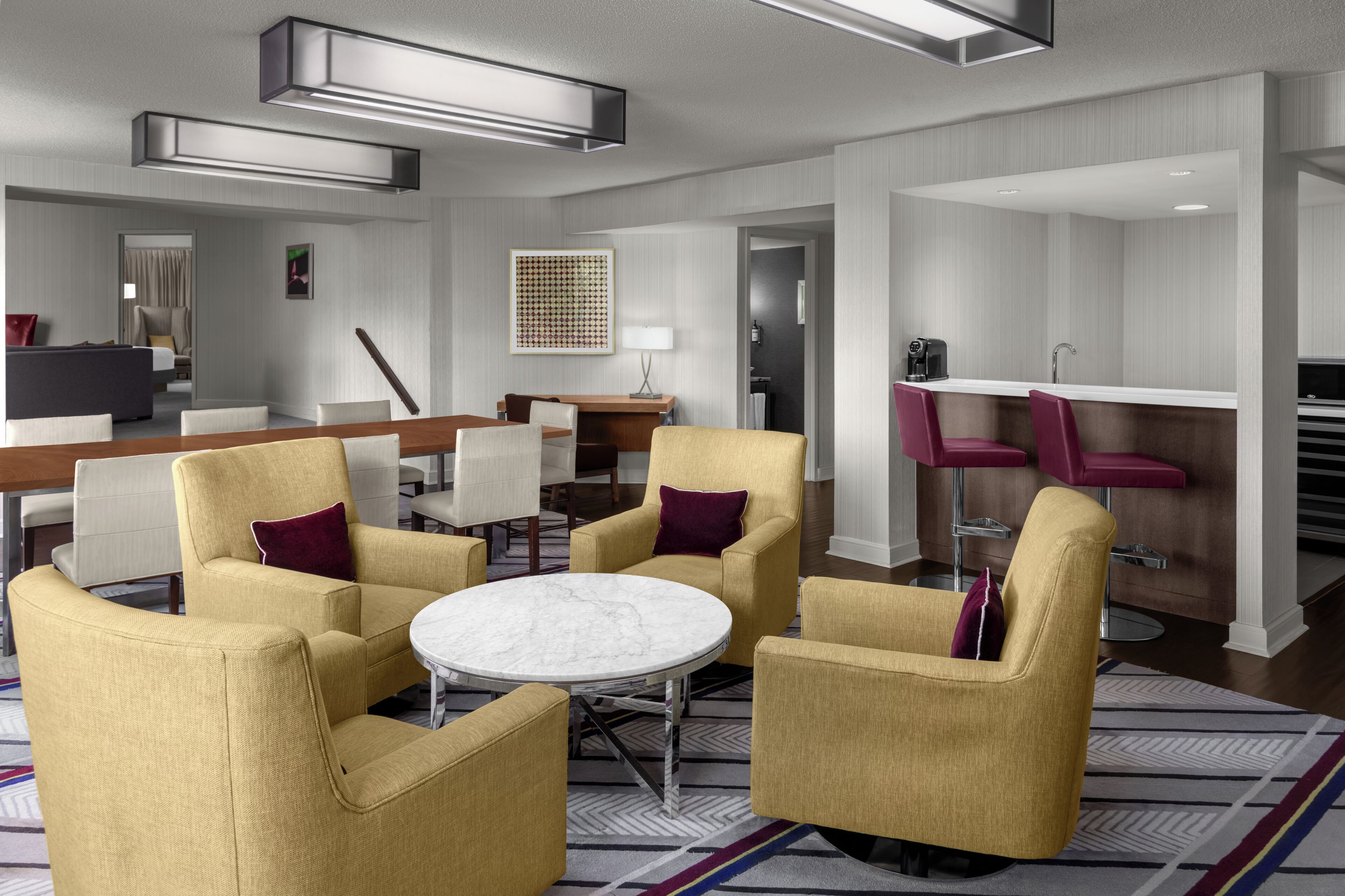 A modern hotel lobby with a seating area, a bar, and a reception desk.