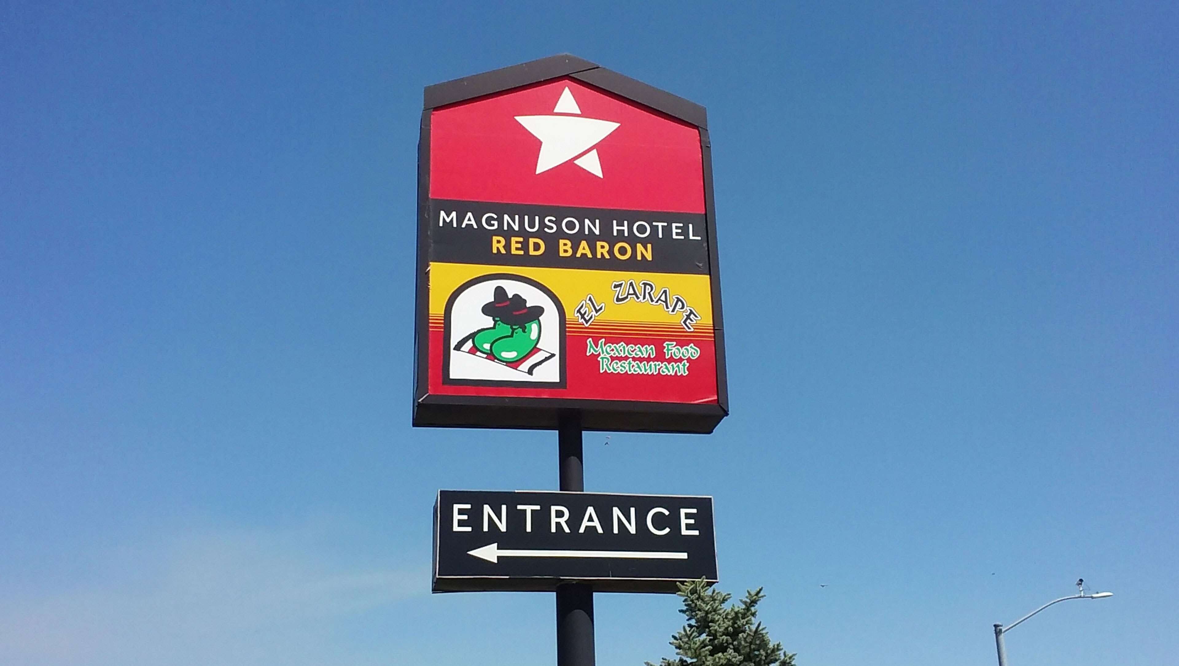 Señal para el Hotel Magnuson Red Baron con indicaciones de acceso.