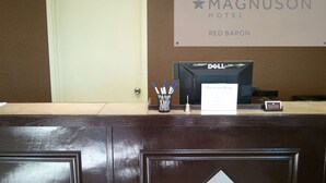 A reception desk at Magnuson Hotel with a sign indicating the location as Red Baron.