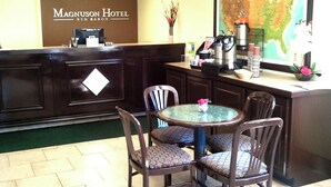 A reception area with a dark wooden reception desk, a glass-top table with chairs, and a large map on the wall.