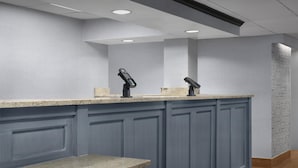 A modern bathroom with a granite countertop, two sinks, and a bench. - Hampton Inn Pittsburgh/Greentree (Pittsburgh)