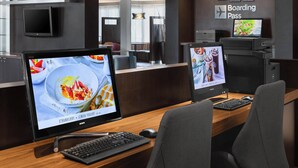 Un moderno mostrador de recepción con un monitor de computadora que muestra un anuncio de postres, un teclado y un ratón.