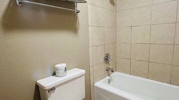 A bathroom with a toilet, a bathtub, and a towel rack.