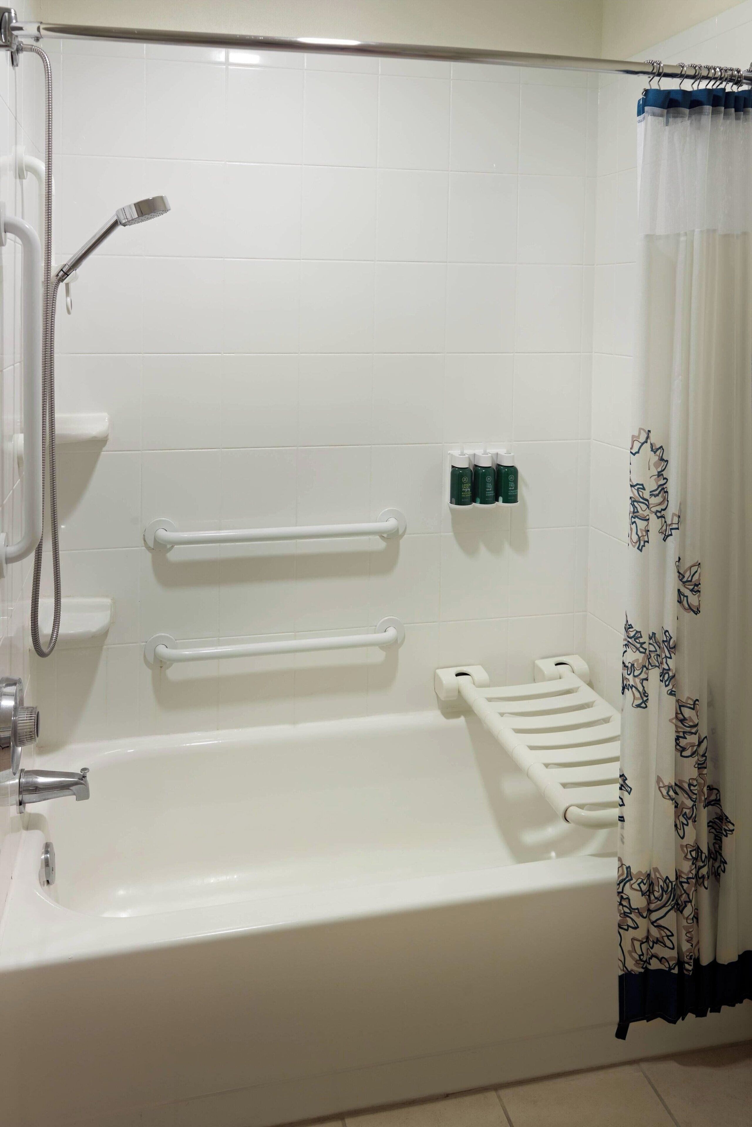 A bathroom with a bathtub, shower, and toilet. There are towel racks and a shelf with toiletries.
