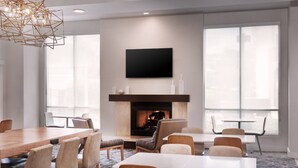 Ein moderner Konferenzraum mit Kamin, Flachbildfernseher und großen Fenstern.