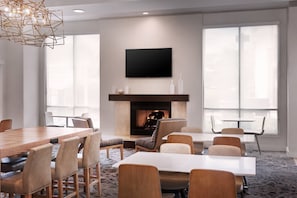 Conference room with a large table, six chairs, and a flat-screen TV above a fireplace.