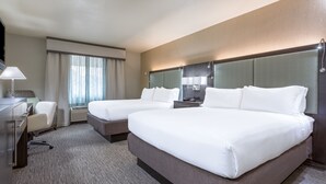 A hotel room with two beds, a desk, a chair, a TV, and a large window with curtains. - Holiday Inn Auburn by IHG (Auburn)