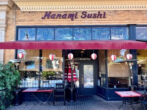 A brick building with a red awning and a sign that reads 'Hanami Sushi.' - Holiday Inn Auburn by IHG (Auburn)