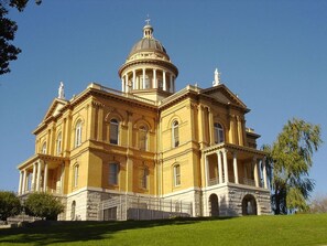 A large, yellow building with a central dome and multiple columns, surrounded by a well-maintained lawn. - Holiday Inn Auburn by IHG (Auburn)