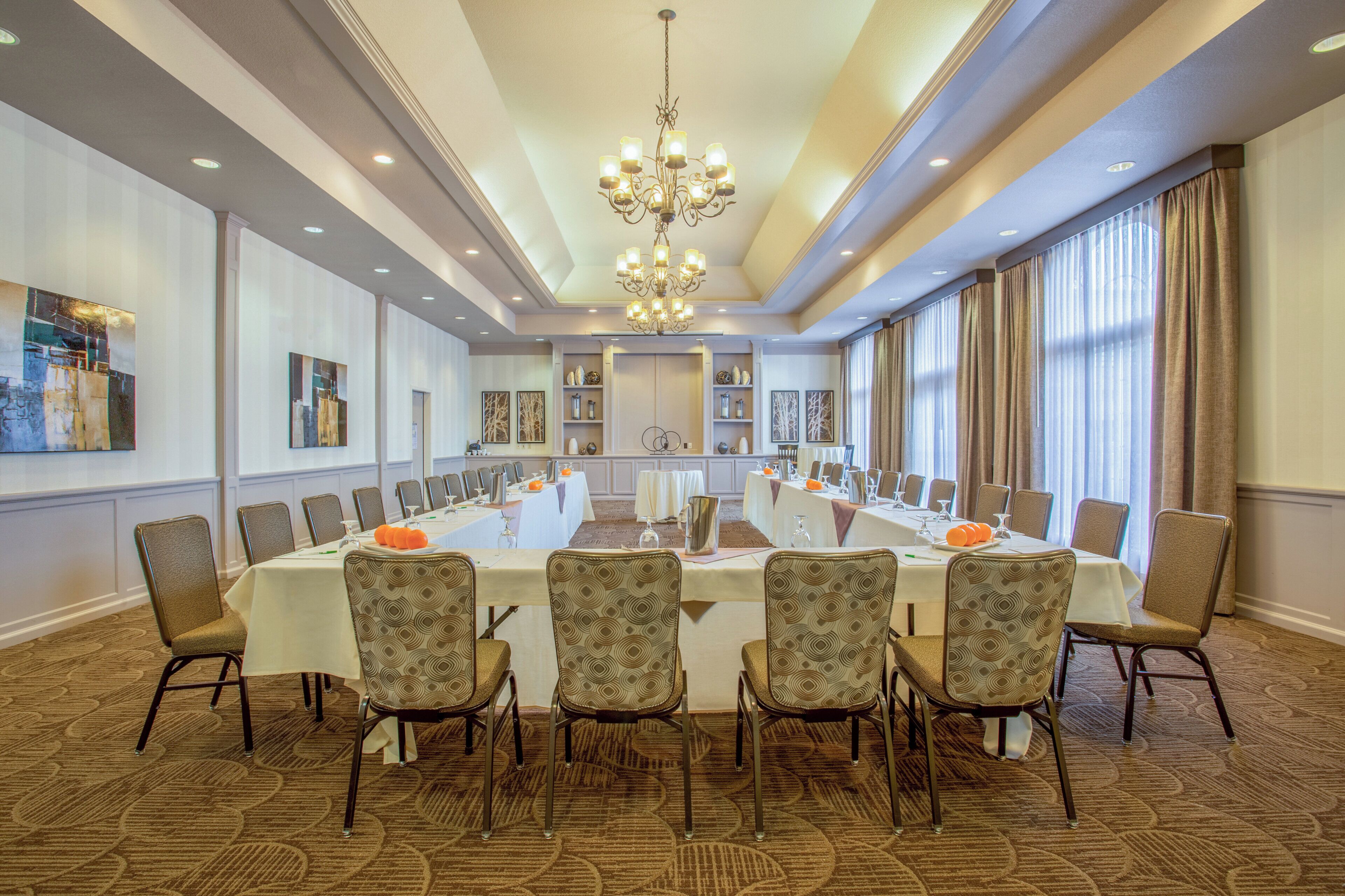 A conference room with a long table, chairs, and a chandelier.
