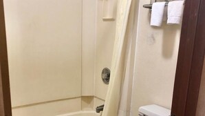 Un baño con bañera, inodoro y cortina de ducha.