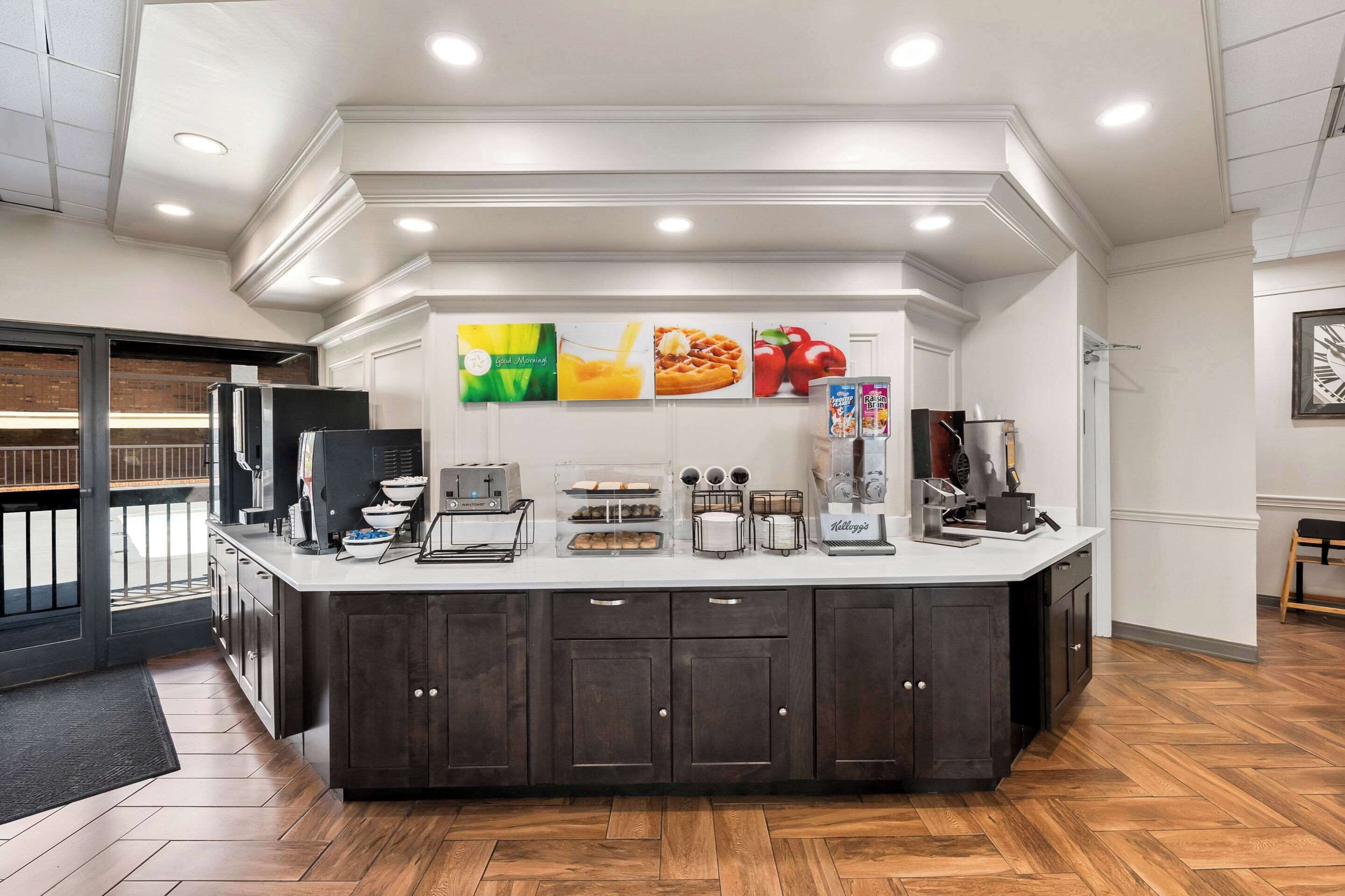A modern kitchen with a central island, built-in appliances, and a breakfast bar.