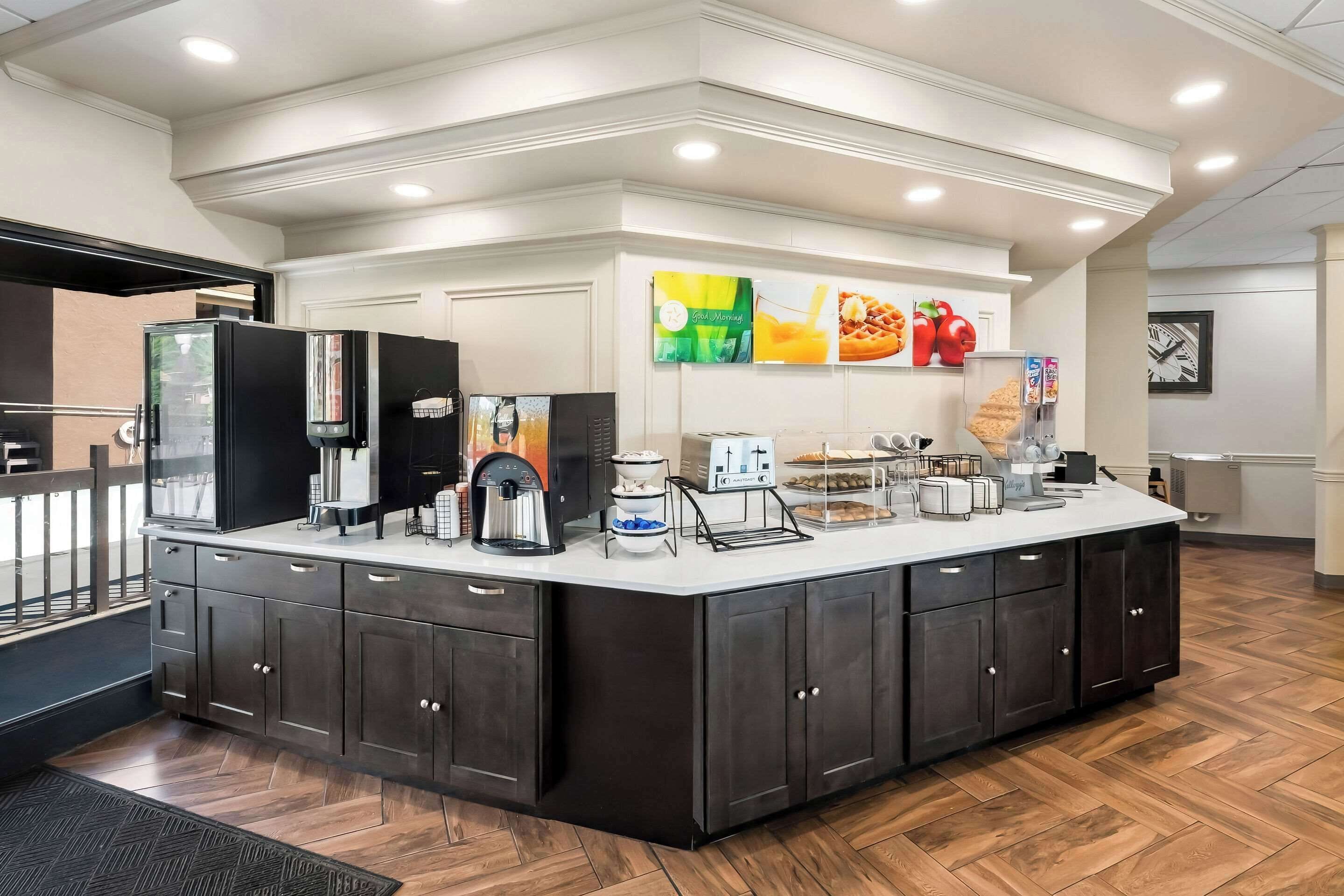 A modern kitchen area with a central island, equipped with a coffee maker, toaster, and various appliances.