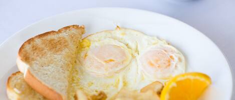 A plate with toast, eggs, and orange slices.