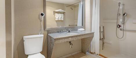 A modern bathroom with a toilet, sink, and shower.