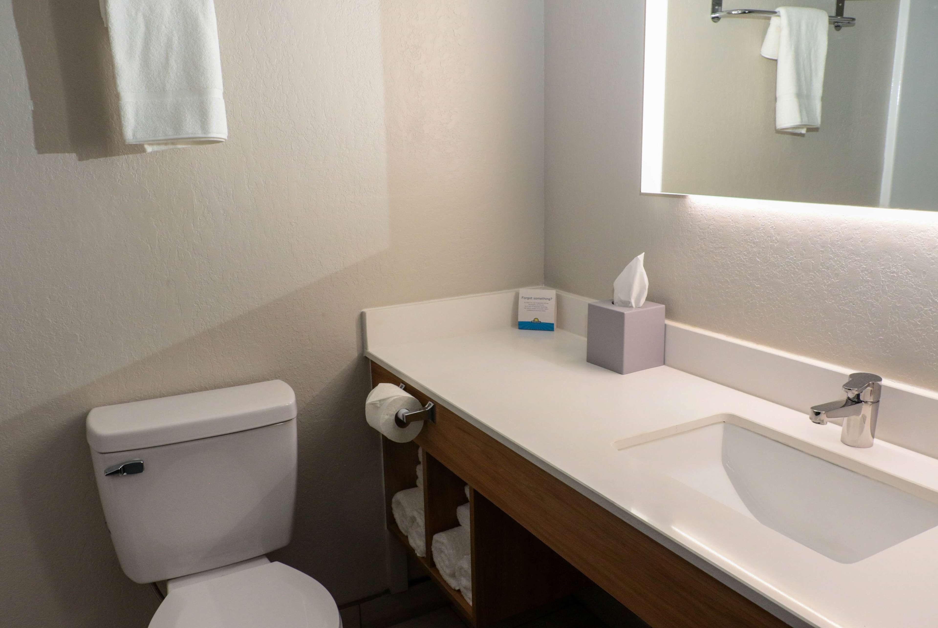 Un bagno con il water, un lavandino e uno specchio.