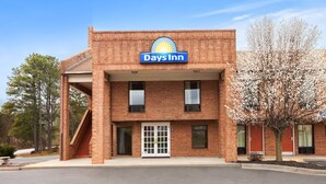 Un hôtel Days Inn avec une façade en briques, une entrée centrale et un parking.