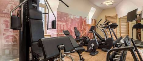 A gym with various exercise equipment, including a bench press, treadmills, and dumbbells.