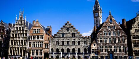 A historic building with a prominent clock tower and a series of arches.