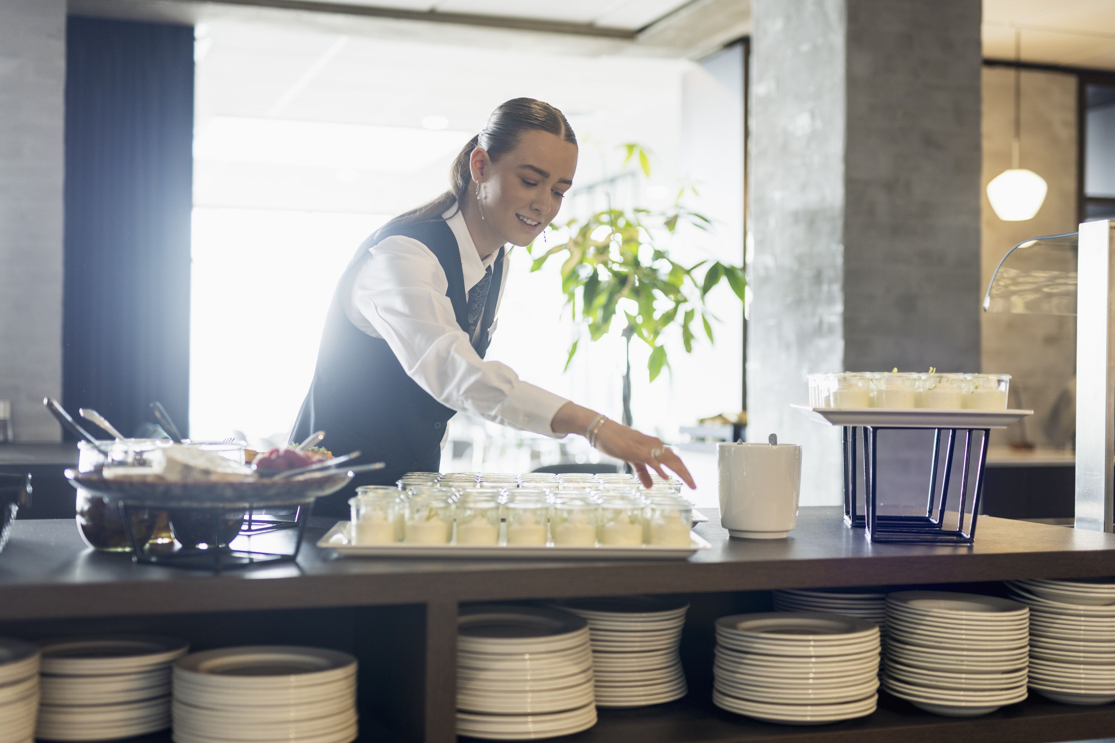 A buffet setup with plates, a tray, and a server.