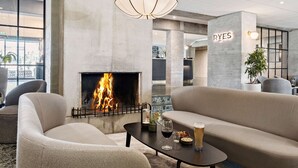 Un área de estar moderna con chimenea, sofás y una mesa con bebidas.