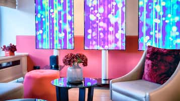 Un interior moderno con un sofá, un reposapiés y una mesa con un jarrón de flores.