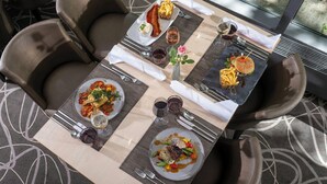 Ein Esstisch mit mehreren Tellern Essen, Weingläsern und Besteck.