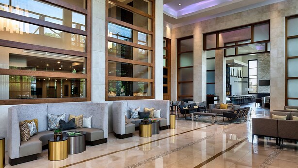 A spacious lobby with a modern design, featuring a large seating area with sofas and armchairs, a coffee table, and a reception desk. - Wyndham Atlanta Buckhead Hotel & Conference Center (Atlanta)