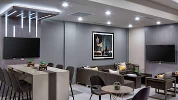 Un moderno vestíbulo de hotel con área de bar, asientos y obras de arte en las paredes.