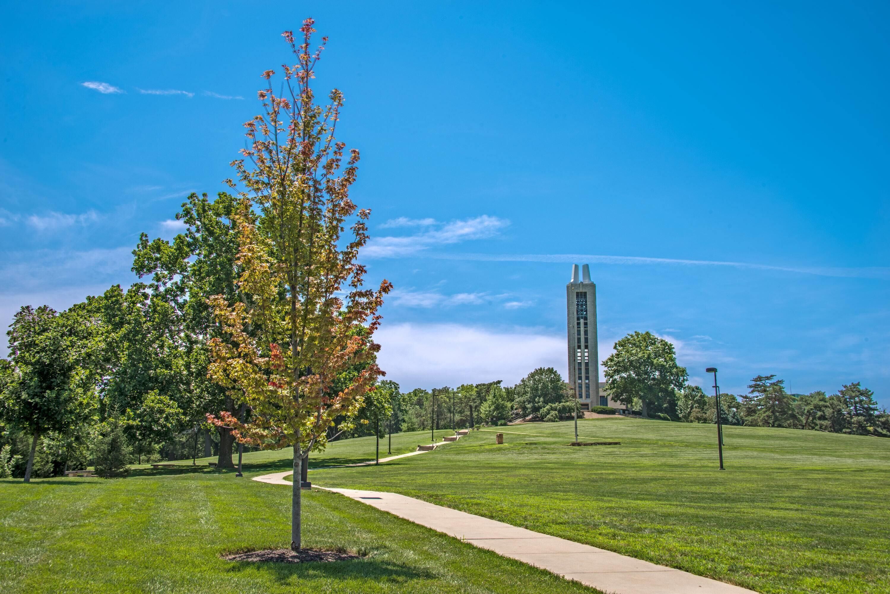 A clear sky, a pathway, and a tall building in the distance.