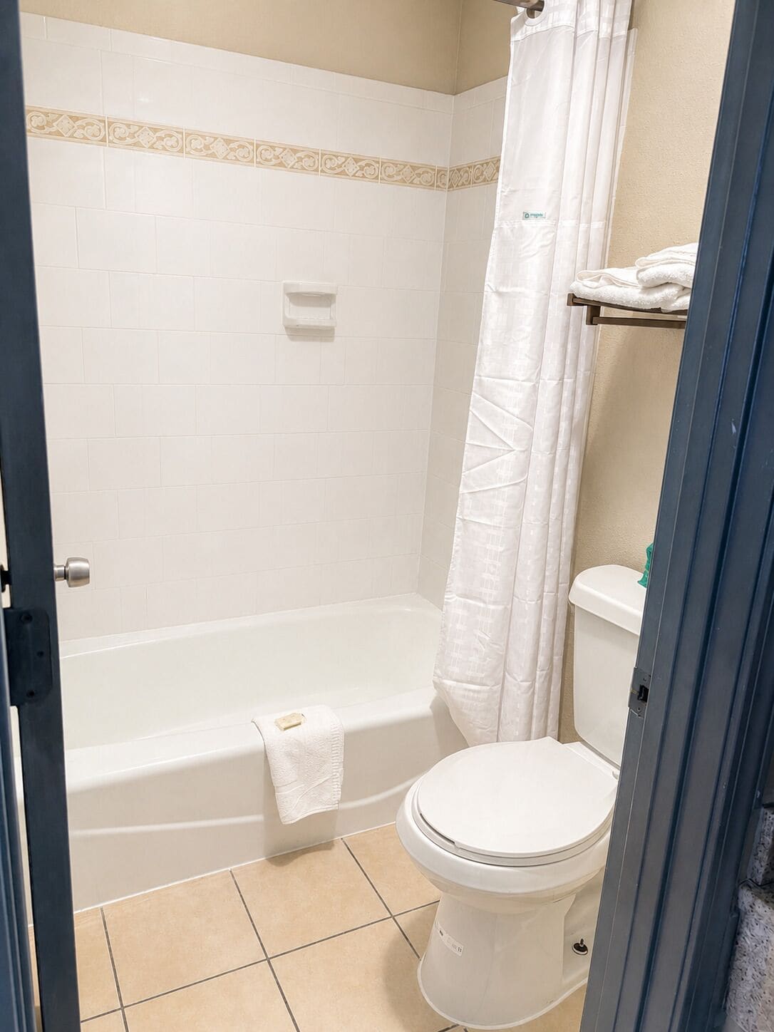 Un baño con bañera, inodoro y cortina de ducha.