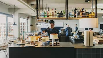 Un bar modern amb un mostrador ple de postres diverses i ampolles de licors.