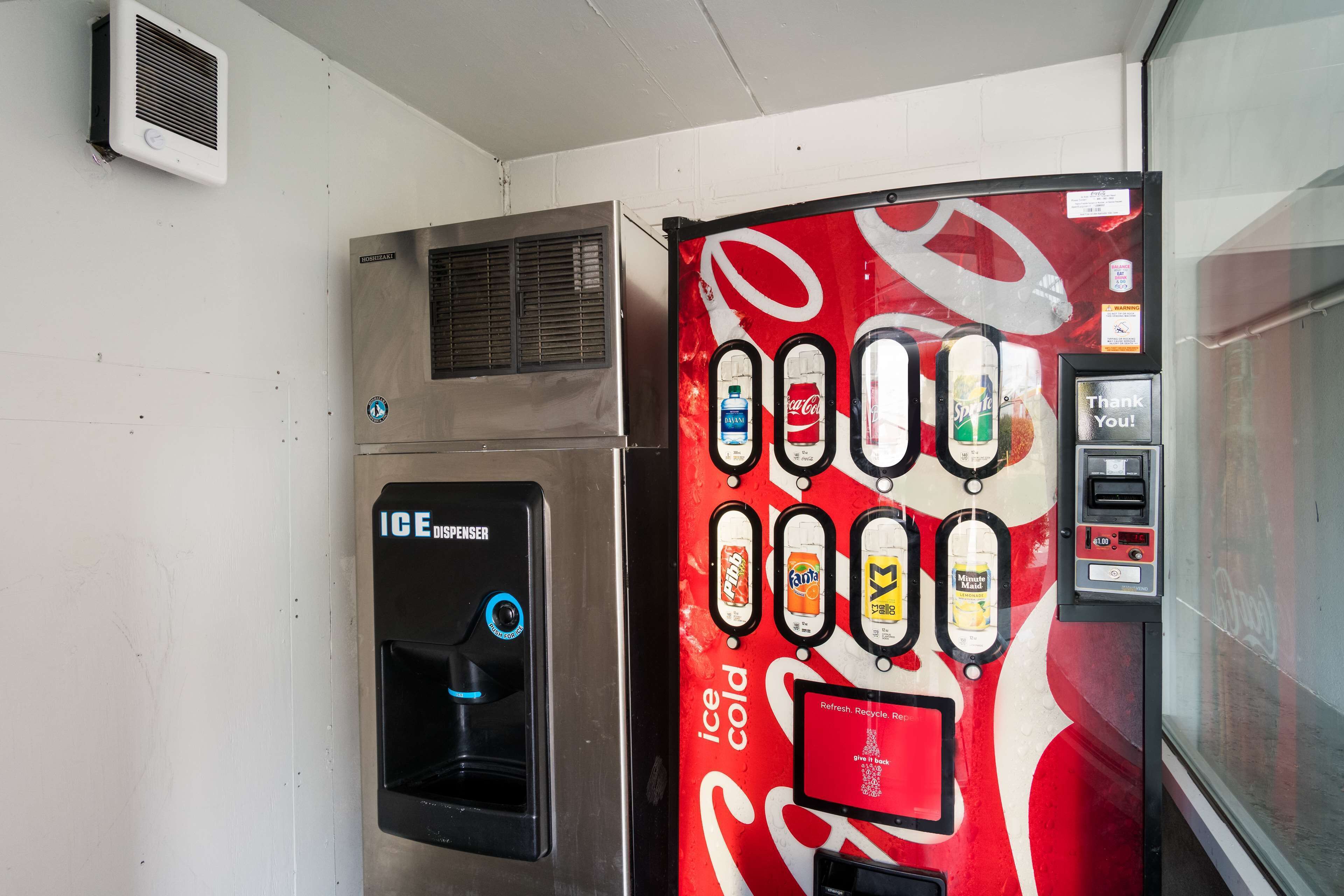 A vending machine with a Coca-Cola logo and a Coca-Cola branded refrigerator.
