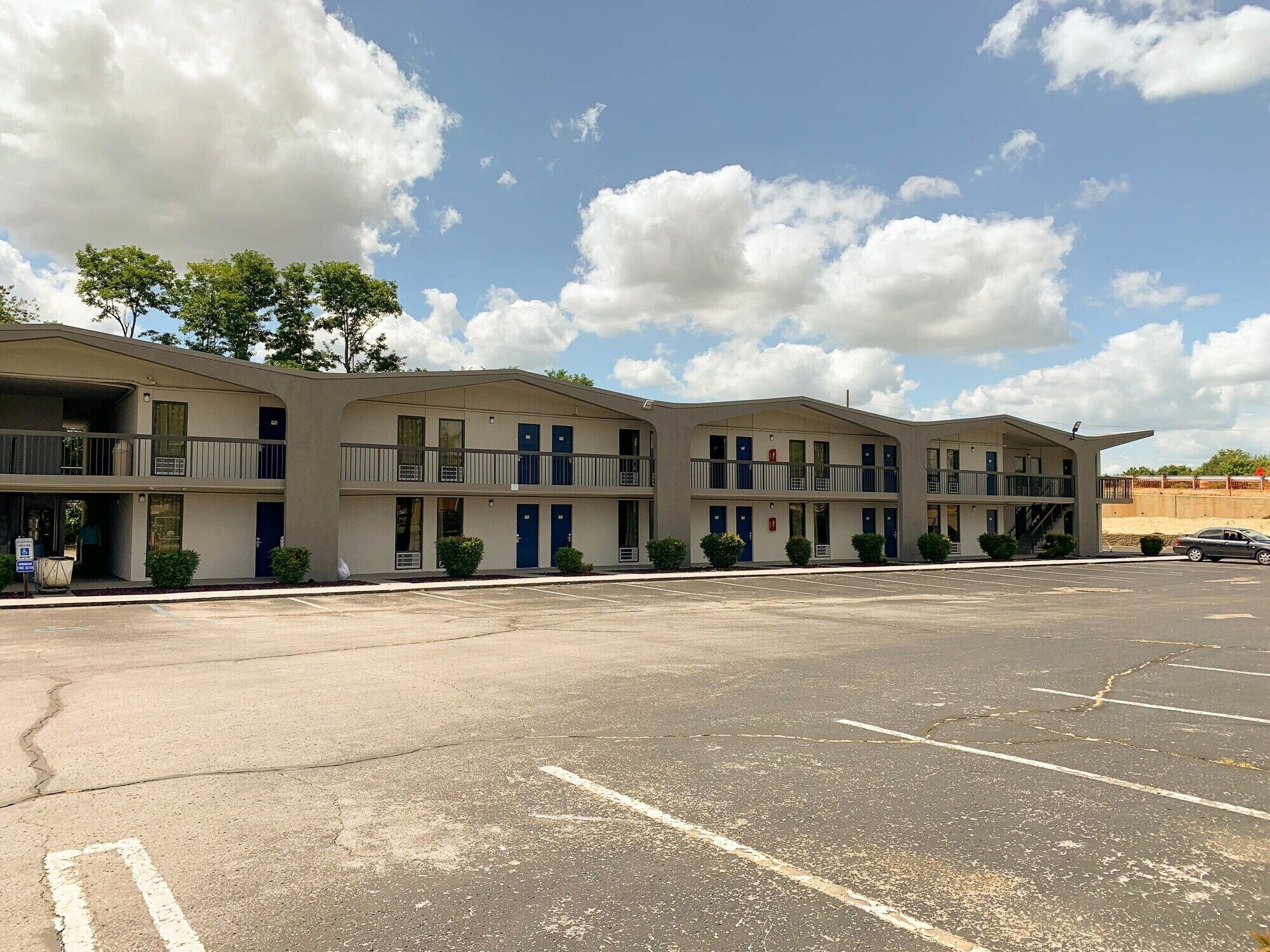 Un motel à plusieurs étages avec un parking situé à l’avant.